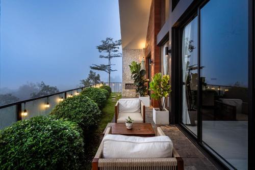 a patio with couches and a table on a balcony at THE MYST VILLA BAO LOC in Ấp Tân Hà
