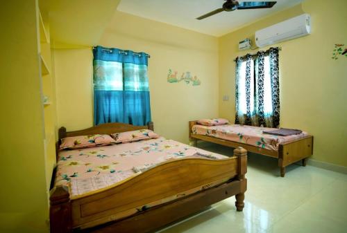 1 dormitorio con 2 camas y ventana en AKC Holiday Home, en Tirunelveli