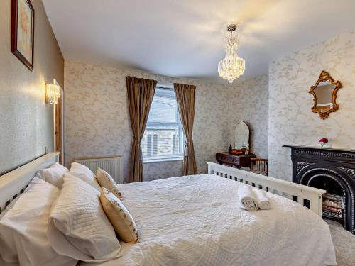 a bedroom with a white bed and a fireplace at 2 Bed in Wooler 92074 in Wooler