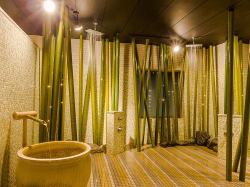 a bathroom with bamboo curtains and a bath tub at The QUBE Hotel Chiba in Chiba