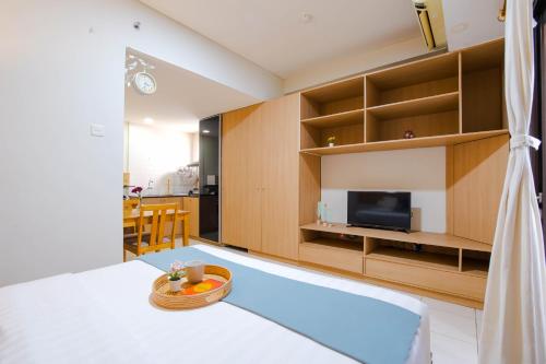 a living room with a bed and a television at Tamansari Sudirman Apartment in Jakarta