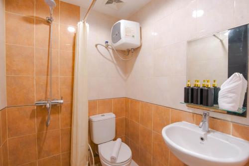 y baño con ducha, aseo y lavamanos. en Tamansari Sudirman Apartment en Yakarta