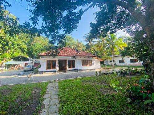 a house with a dog standing in front of it at Happy Valley Residence Unawatuna in Galle