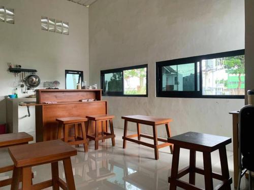 um quarto com mesas de madeira e um piano em Villa di Malang Dekat Kampus Ternama em Malang