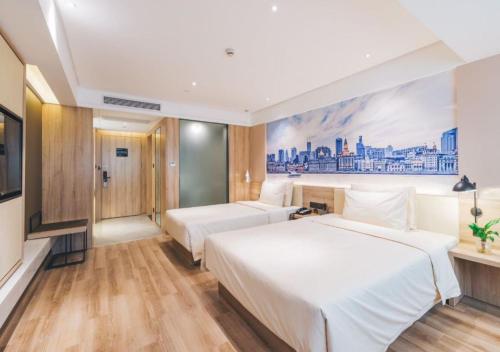 a bedroom with two beds and a painting on the wall at Atour Hotel New International Expo Center Longyang Road Shanghai in Shanghai