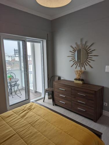 a bedroom with a bed and a dresser and a mirror at Oceanview 2 Bedroom suite 5 adults PDL in Ponta Delgada