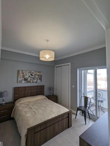 a bedroom with a bed and a table and a chair at Oceanview 2 Bedroom suite 5 adults PDL in Ponta Delgada