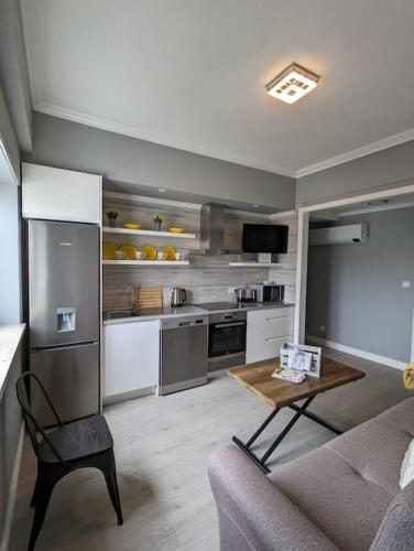 a kitchen and living room with a couch and a table at Oceanview 2 Bedroom suite 5 adults PDL in Ponta Delgada