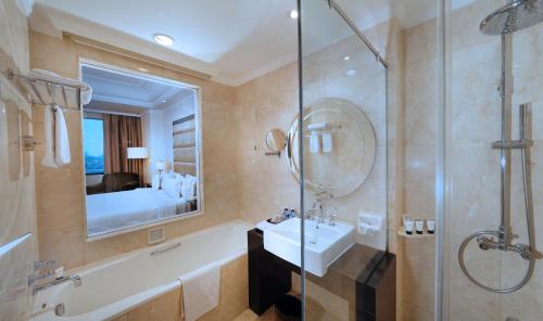 a bathroom with a tub and a sink and a shower at The Papandayan in Bandung