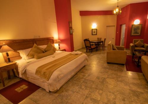 a bedroom with a large bed and a living room at La Palm Royal Beach Hotel in Accra