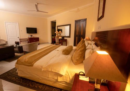 a bedroom with a large bed and a living room at La Palm Royal Beach Hotel in Accra