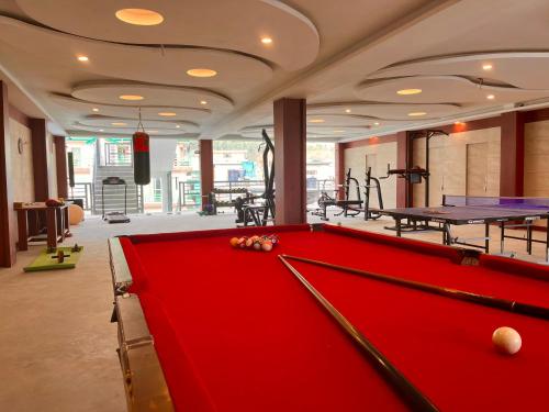 una mesa de billar en una habitación con mesas de ping pong en TATA Vista Resort Mall Road Manali - Centrally Heated & Air Cooled, en Manali