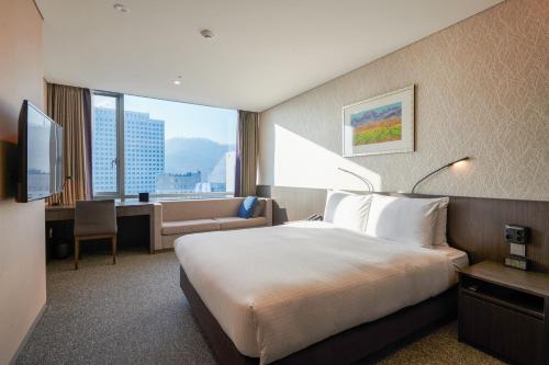 a hotel room with a bed and a desk at Nine Tree by Parnas Seoul Myeongdong 2 in Seoul