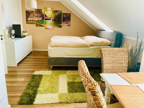 Zimmer mit einem Bett und einem Tisch mit einem Teppich in der Unterkunft Weidelandfarm am Riebener See in Beelitz