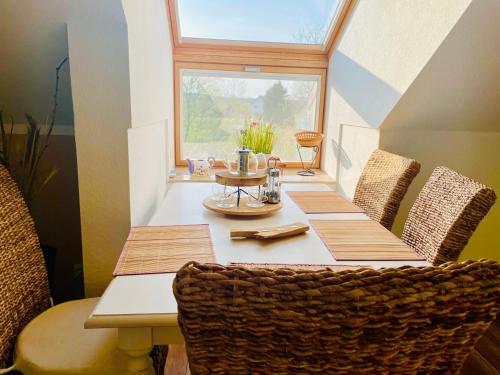 einen Esstisch mit Stühlen und ein Fenster in der Unterkunft Weidelandfarm am Riebener See in Beelitz