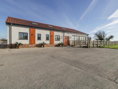 a white building with a red roof and a fence at Bilsham Meadows in Bristol