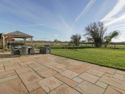 a patio with chairs and a gazebo in a field at Bilsham Meadows in Bristol