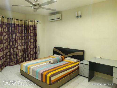 um quarto com uma cama, uma cómoda e uma ventoinha de tecto em Kulim Square Homestay em Lunas