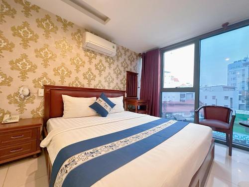 ein Schlafzimmer mit einem Bett und einem großen Fenster in der Unterkunft Kim Dung Hotel Tran Quang Khai in Ho-Chi-Minh-Stadt
