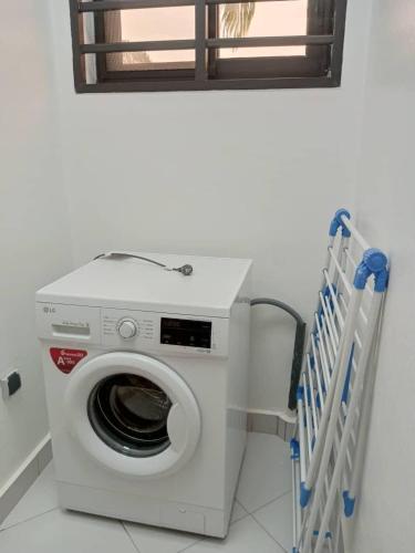 a washing machine in a bathroom with a window at Villa luxueuse in Abomey-Calavi