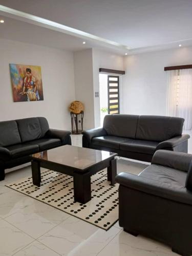 a living room with couches and a coffee table at Villa luxueuse in Abomey-Calavi