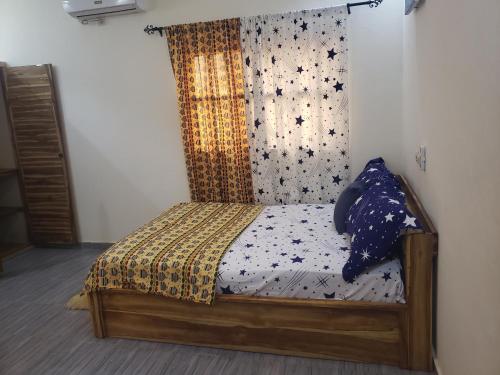a small bed in a room with a quilt at Fafape in Lomé