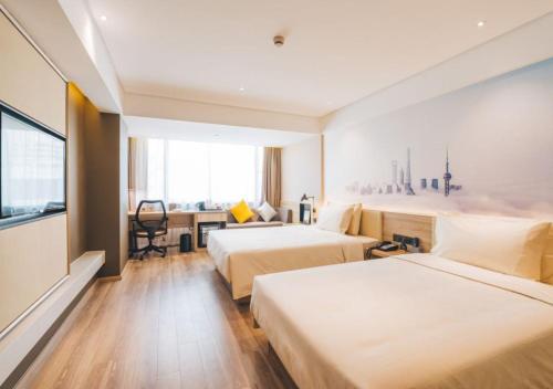 a hotel room with two beds and a desk at Atour Hotel New International Expo Center Longyang Road Shanghai in Shanghai
