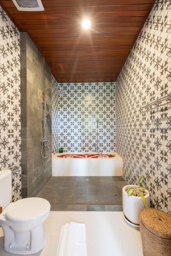 a bathroom with a toilet and a bath tub at Oka Suite Sebatu Ubud in Tampaksiring