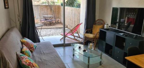 - un salon avec un canapé et une table en verre dans l'établissement Coquet Rez jardin plage parking wifi, à Saint-Mandrier-sur-Mer