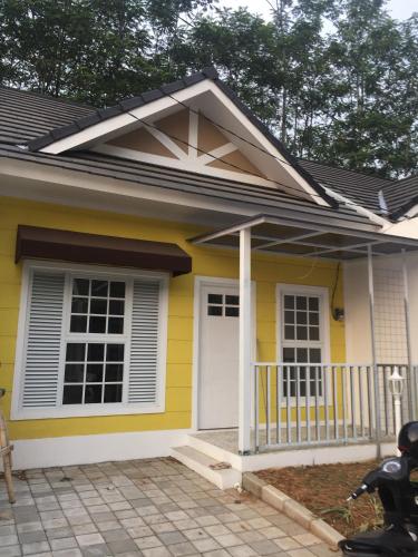 a small yellow house with a white door at Jojo House 