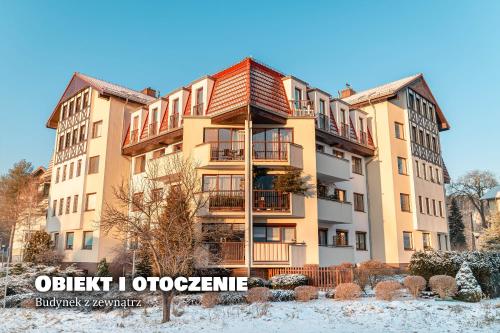 an apartment building with snow on the ground at Apartament Fotografa in Polanica-Zdrój