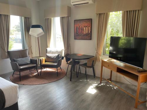 a hotel room with a bed and a desk and a television at Vintages Accommodation in Margaret River Town