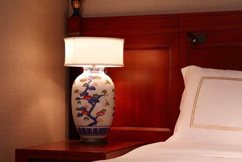 a large vase sitting on a table next to a bed at Hotel Chinzanso Tokyo in Tokyo