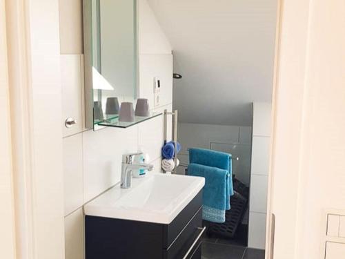 a white bathroom with a sink and a mirror at Ferienhaus Engelsberghof in Endingen