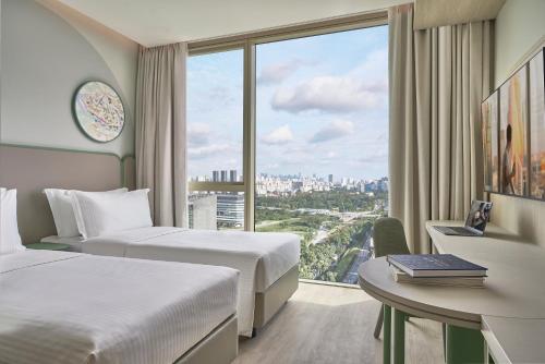 新加坡Citadines Science Park Singapore的一间有两张床、一张桌子和一扇窗户的酒店房间