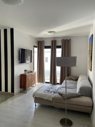 a bedroom with a bed and a television in it at PURA VIDA Beach Suite in Arguineguín