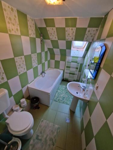 a bathroom with a tub and a toilet and a sink at Casa Tru in Zărneşti