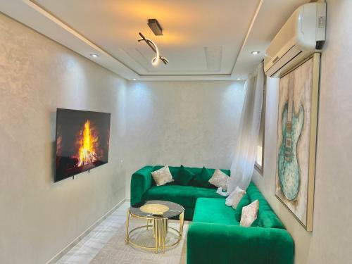 - un salon avec un canapé vert et une table dans l'établissement Appartement entièrement neuf au cœur de Témara, à Temara