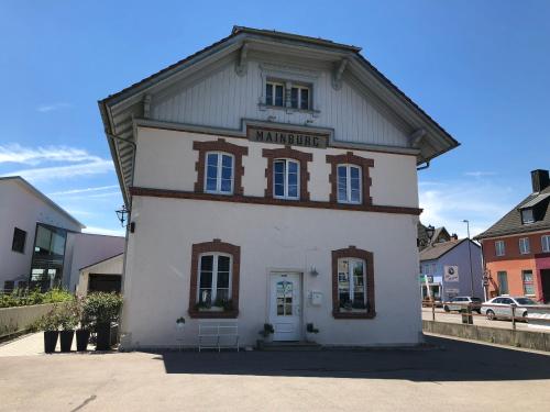 - un petit bâtiment blanc avec un panneau dans l'établissement Pension Schönhuber, à Mainburg