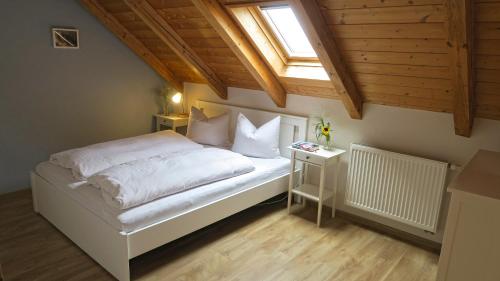 a bedroom with a white bed and a window at Pension Schönhuber in Mainburg