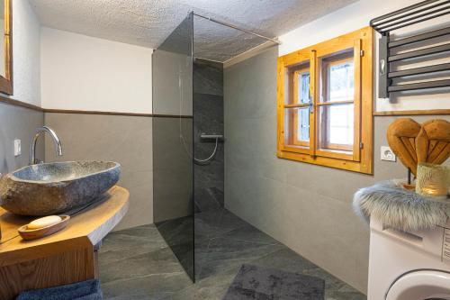 ヴェルフェンにあるAlmfriedenのバスルーム(洗面台、ガラス張りのシャワー付)