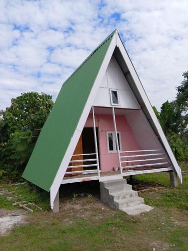 a small pink and white house with a triangular roof at Wood Town Resort in Kharem