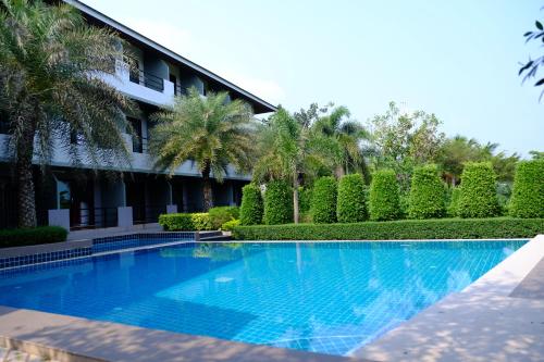 a swimming pool in front of a building at Evergreen Resort Chanthaburi in Chanthaburi