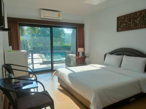 a bedroom with a bed and a large window at Evergreen Resort Chanthaburi in Chanthaburi