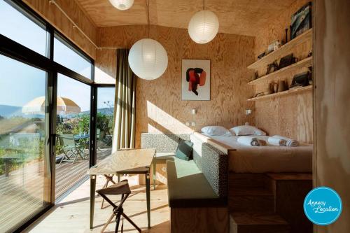 1 dormitorio con cama, escritorio y ventana en Ecolodge Acm Vue Lac Et Bain Nordique, en Rovagny