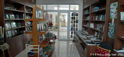 una biblioteca con muchos estantes llenos de libros en Mutiara Balige Hotel en Balige