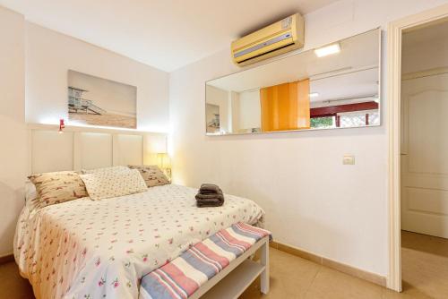1 dormitorio con cama y espejo en Casita playa, en Málaga