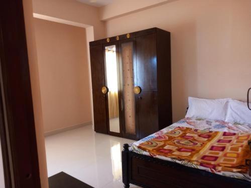 1 dormitorio con 1 cama con cabecero de madera y ventana en Reef Hotel 1, en Hyderabad