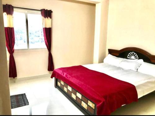 1 dormitorio con 1 cama con manta roja y ventana en Reef Hotel 1, en Hyderabad