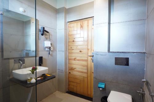 een badkamer met een wastafel, een toilet en een douche bij Corbett Nirvana Resort in Rāmnagar